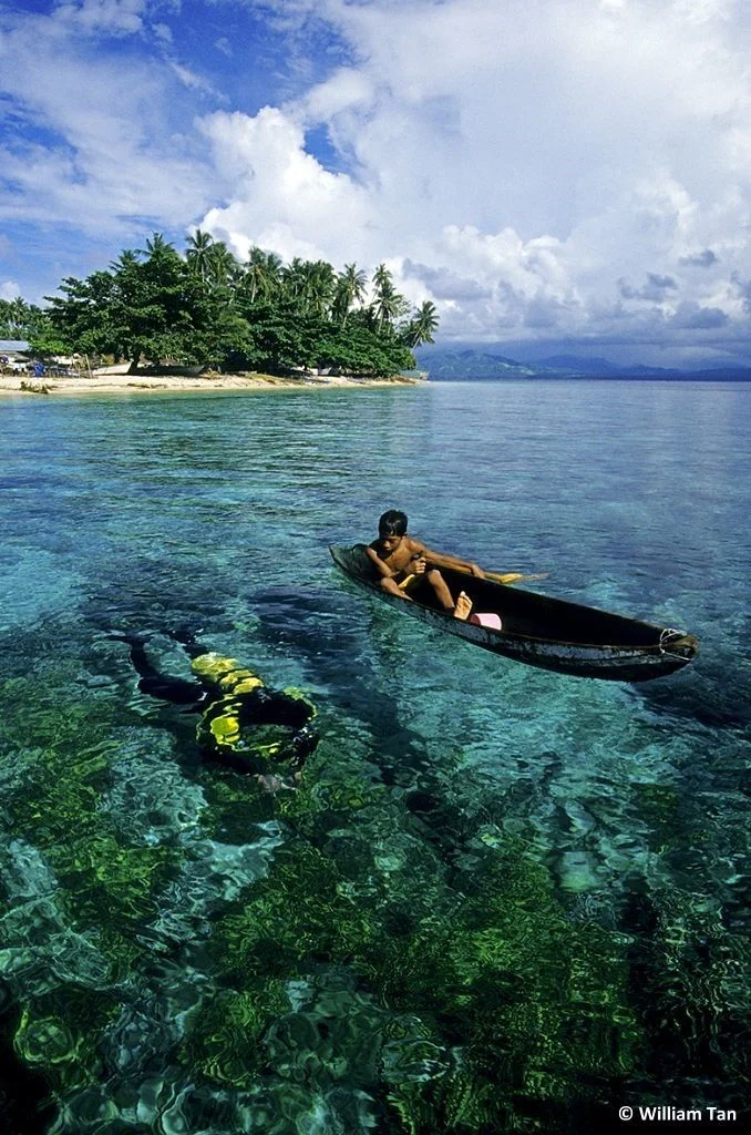 Diver and kid in kayak, Bunaken, North Sulawesi, Indonesia