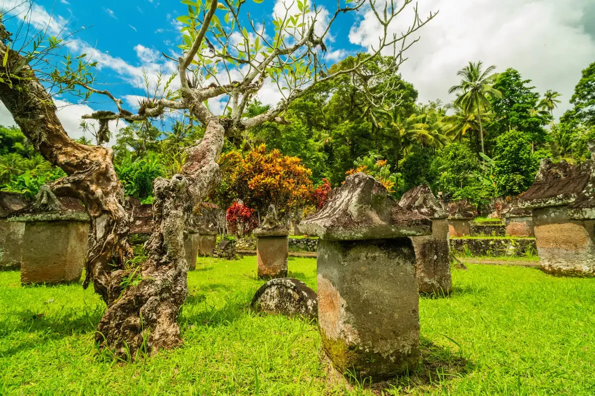 Panoramic park view of the ancient Waruga stone tomb collection under a bright tropical sky in North Sulawesi.